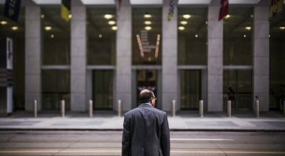 businessman in front of empty street across from office building