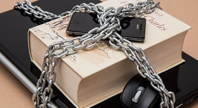 laptop book and smartphone locked in chains