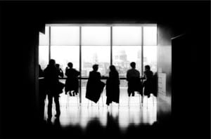people talking at counter in front of windows