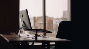 laptop on standing desk in front of window