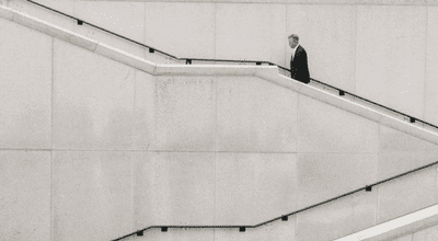 businessman walking up two flights of cement stairs